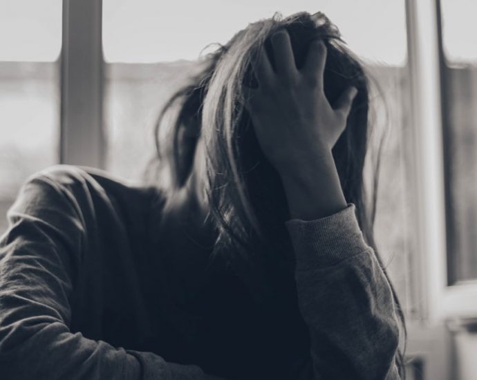 grayscale photography of person covering face